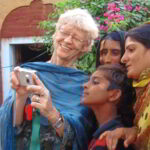 Ehrenamt im Ruhestand: Eine ältere deutsche Frau zeigt drei pakistanischen Frauen Fotos auf ihrer Kompaktkamera. Ehrenamtliches Engagement im Alter vermittelt u.a. der Senior Expert Service, Freiwilligenagenturen oder gemeinnützige Organisatonen und Stiftungen. Foto: SES Bonn