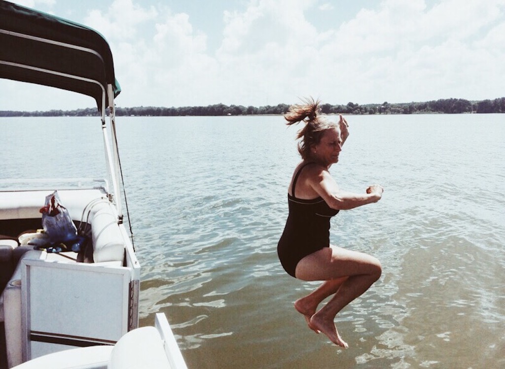 Eine Frau springt fröhlich vom Boot in einen See. Es braucht Mut, nach eigenen Vorstellungen zu leben.
