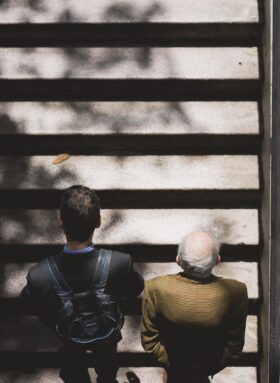 Zwei Männer auf einer Treppe. Vom Austausch profitieren Jung und Alt.