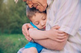 Dankbarkeit: ein glücklicher Enkel umarmt seinen Großvater.